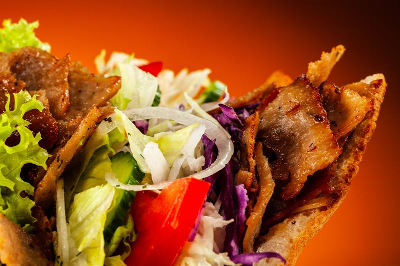 Close up of a doner kebab packed with crisp salad and tomato